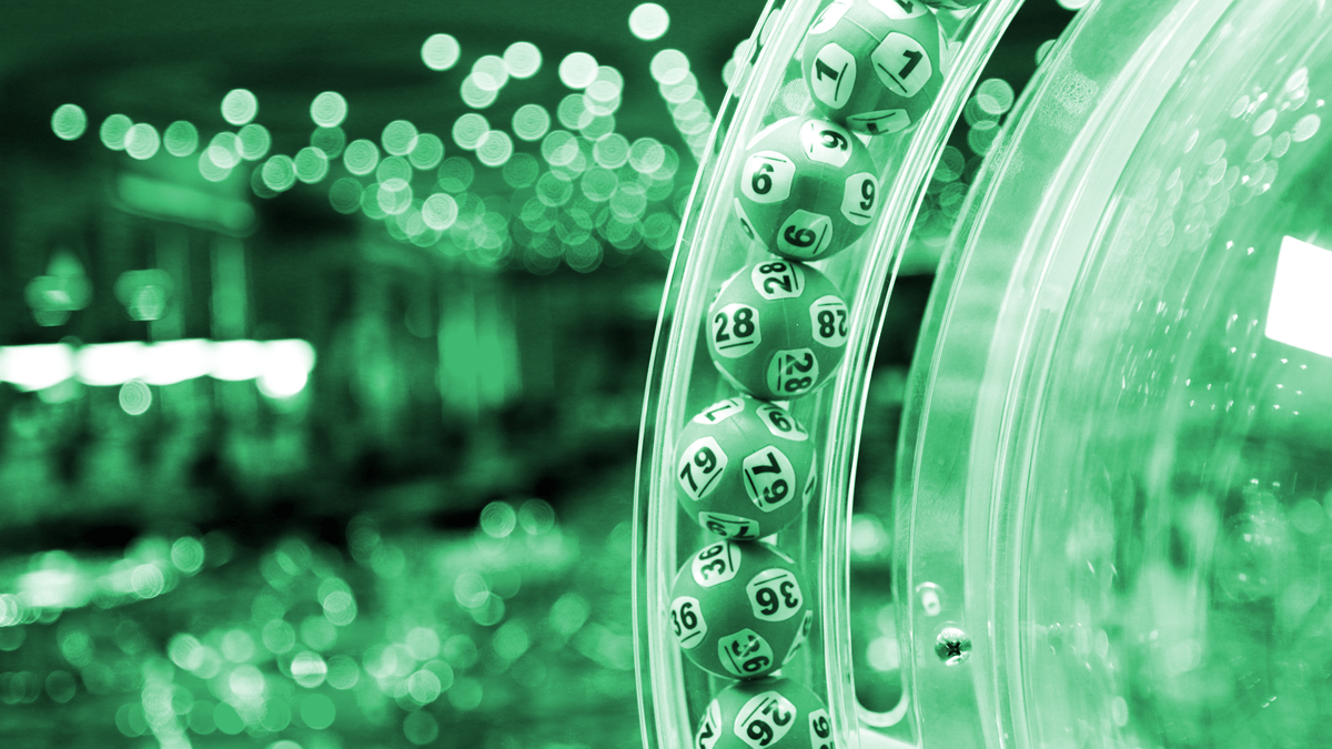 Färgade bingobollar med siffror snurrar i en genomskinlig maskin under ett spel.